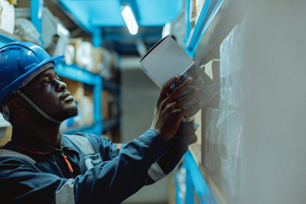 Profissional industrial com capacete a analisar um documento no chão de fábrica