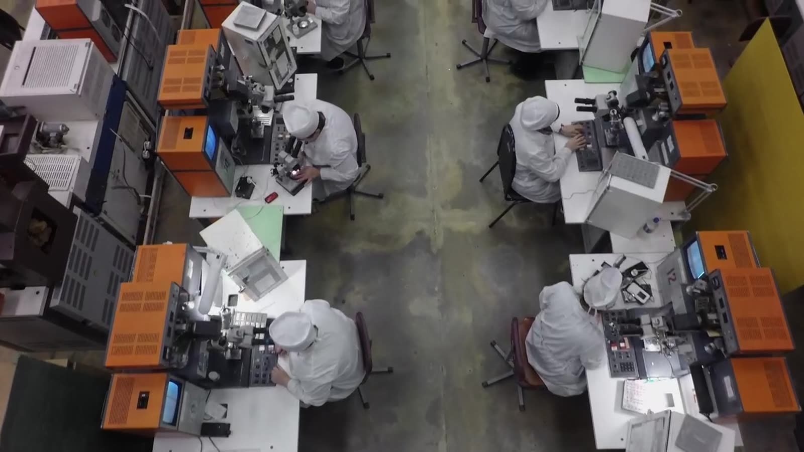 Equipa a trabalhar lado a lado em bancadas de uma oficina