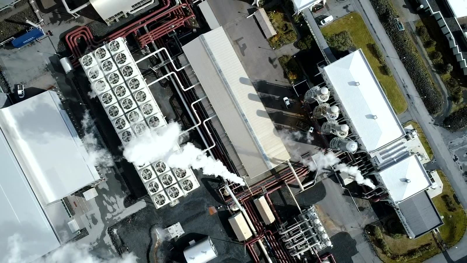 Vista de cima de uma fábrica com linhas de produção e zonas de armazenamento